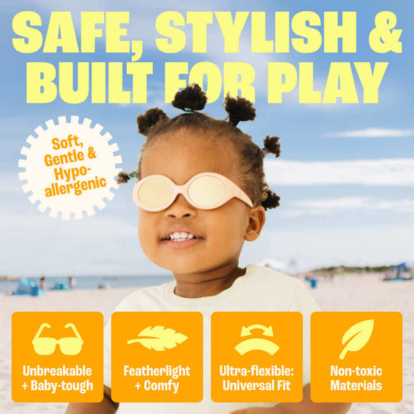 Black Flexible Polarized Baby Sunglasses With Strap 0-24 Months - Oval on a child at the beach with safety features highlighted.